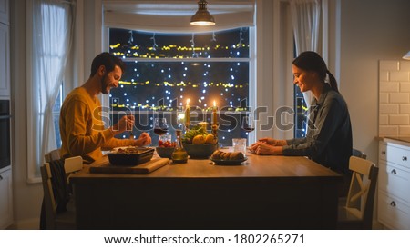 Happy Young Couple in Love Have Romantic Dinner, Eating Tasty Meal in the Kitchen, Celebrating, Talking. Beautiful Lovely Husband and Wife Have Romantic Time