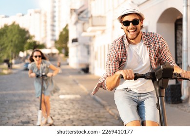 Happy young couple in love on vacation having fun, driving electric scooter through the city. Eco transport. Adventure and vacation concept - Powered by Shutterstock