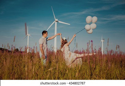 Happy young couple. Lovers enjoying life. The guy with the girl on the nature. Love and tenderness. Beautiful pregnant girl. Beautiful couple relaxing on the beach. Air balloons in hands.  - Shutterstock ID 434802787