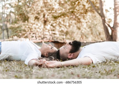 happy young couple lying on grass with raised hands and feeling free, freedom man and woman looking at sky, love and relax in relationship - Shutterstock ID 686756305