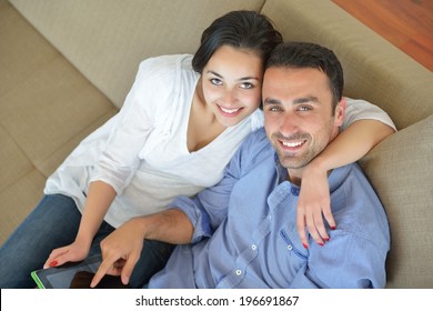 glückliches junges Ehepaar im modernen Zuhause mit Tablet-Computer