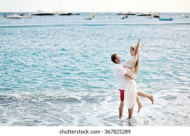 Happy Young Couple On The Beach Of Positano, Amalfi Coast, Italy