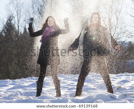 Happy young couple outdoors playing in snow