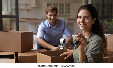 Happy young couple pack their belongings move out of rented house to their own, Hispanic wife smile look at camera hold bunch of keys symbol of relocation, bank loan and life changes, move day concept - Shutterstock ID 2067029507