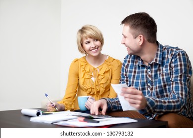 Happy Young Couple Paying Bills At Home.