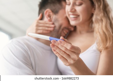 Happy young couple with pregnancy test in bathroom, closeup - Powered by Shutterstock