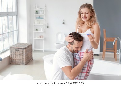 Happy Young Couple With Pregnancy Test In Bathroom