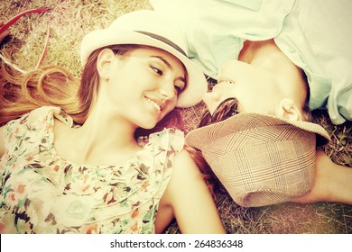 Happy Young Couple Relaxing On The Lawn In A Summer Park. Love Concept. Vacation.