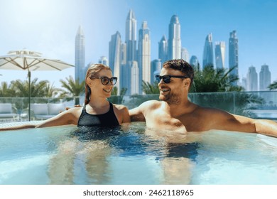 happy young couple relaxing in outdoor hot tub at Dubai hotel. luxury vacation, getaway travel - Powered by Shutterstock