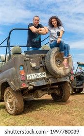 Happy Young Couple Resting On The Dirty Offroad Car. Highland Car Tour. Carpathian Mountains, Ukraine - 07.27.2016