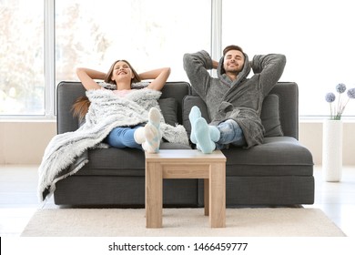 Happy young couple resting together on sofa at home - Powered by Shutterstock