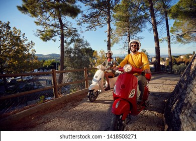 Happy Young Couple Riding On A Scooter In Old European Town On Vacation
