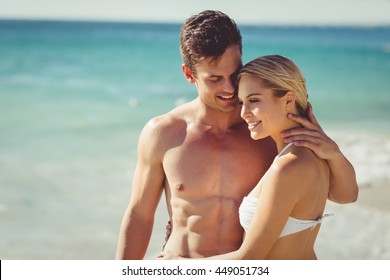 Happy Young Couple Romancing On Beach