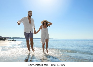 Happy young couple running on beach near sea. Honeymoon trip - Powered by Shutterstock