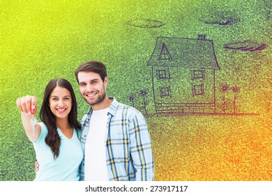 Happy Young Couple Showing New House Key Against Astro Turf Surface