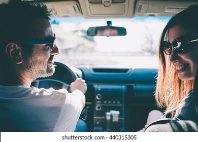 Happy young couple sit in a car. Travel and adventure concept. Toned picture