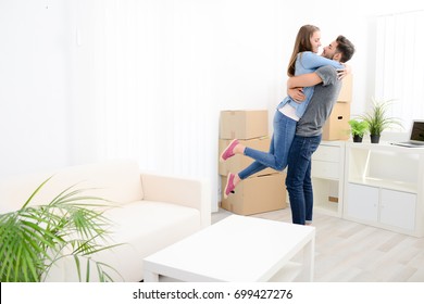 Happy Young Couple Student Roommate Packing Boxes And Moving Furniture During Their Move Into New Home Flat Apartment