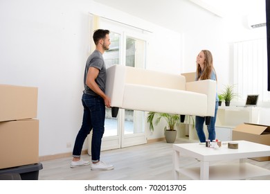 Happy Young Couple Student Roommate Packing Boxes And Moving Furniture During Their Move Into New Home Flat Apartment