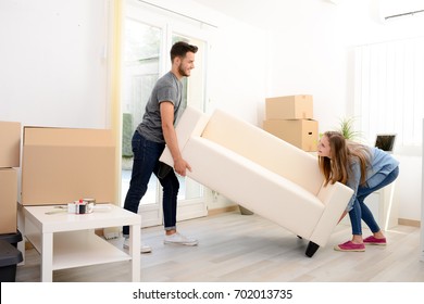 happy young couple student roommate packing boxes and moving furniture during their move into new home flat apartment