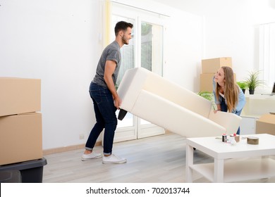 Happy Young Couple Student Roommate Packing Boxes And Moving Furniture During Their Move Into New Home Flat Apartment