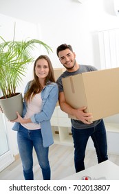 Happy Young Couple Student Roommate Packing Boxes And Moving Furniture During Their Move Into New Home Flat Apartment