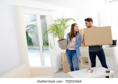 Happy Young Couple Student Roommate Packing Boxes And Moving Furniture During Their Move Into New Home Flat Apartment