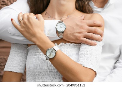 Happy young couple with stylish wrist watches, closeup