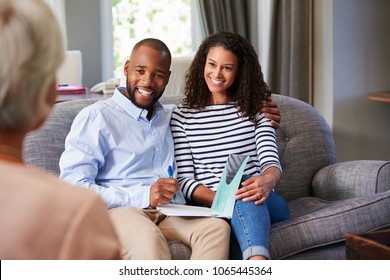 Happy young couple taking financial advice at home - Powered by Shutterstock