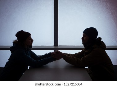 Happy Young Couple Travelers On Vacation Looking At Each Other And Holding Hands Inside Of Hotel Ski Resort In The Mountains