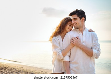 Happy young couple two friends family man woman in casual clothes hug girlfriend put head on boyfriend shoulder at sunrise over sea sand beach ocean outdoor exotic seaside in summer day sunset evening