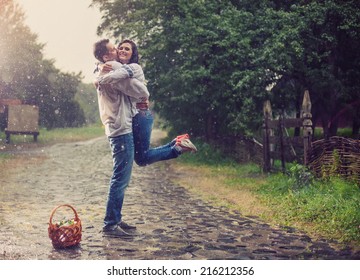 Happy Young Couple In Ukrainian Style Clothes Hugging Under Rain