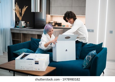 Happy Young Couple Unpacking Brand New Gaming Console Sony Playstation 5 At Home. Moscow - November 28 2020.