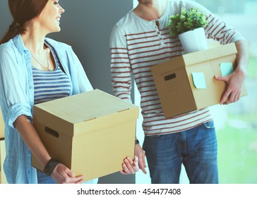 Happy Young Couple Unpacking Or Packing Boxes And Moving Into A New Home