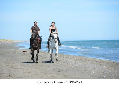 happy young couple vacation riding horses on the beach in sunny summer day - Powered by Shutterstock