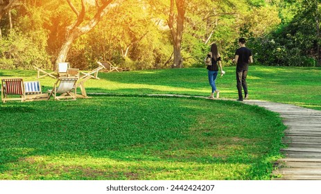 Happy young couple walking with a cup of drinks on sidewalk on a sunny day in park. Lovers wear casual clothes enjoys relaxing with beverage in garden on summer weekend. Outdoor relaxing with drinks. - Powered by Shutterstock