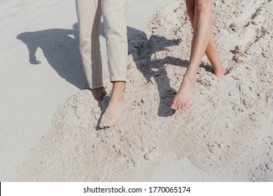 Happy young couple walking on the sand. Couple legs. Love story. High quality photo