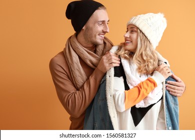 Happy Young Couple In Warm Autumn Clothes On Color Background