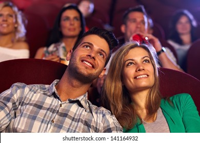 Happy young couple watching movie in cinema, smiling. - Powered by Shutterstock