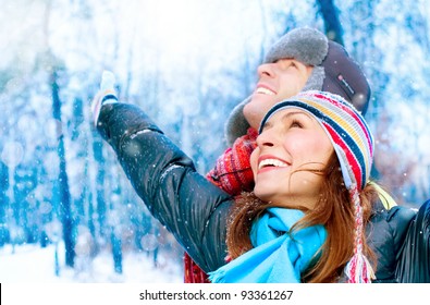 Happy Young Couple in Winter Park having fun.Family Outdoors