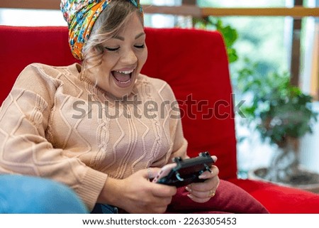 Happy young curvy woman checking social media holding smartphone at home, smiling woman using mobile phone app playing game, shopping online, ordering delivery and relax on sofa