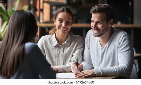 Happy young customers couple ready to sign bank loan agreement meeting broker agent, smiling husband and wife consider finance investing insurance contract deal decide on lease offer listen insurer
