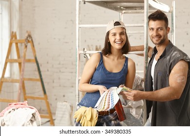 Happy Young Diy Couple Building New Home, Choosing Paint Colors, From Color Scale.