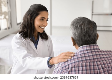 Happy young doctor woman enjoying medical job, giving support to older patient, talking to man for healthcare examination, checkup, touching shoulder with support, sympathy - Powered by Shutterstock