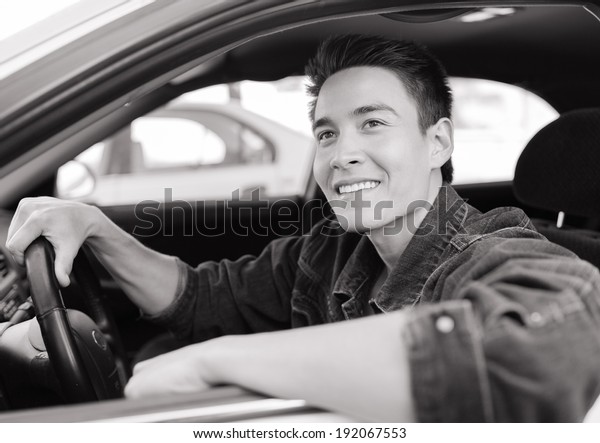 Happy young driver man in\
the car.