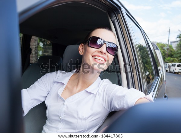 Happy young driver woman\
in the car.