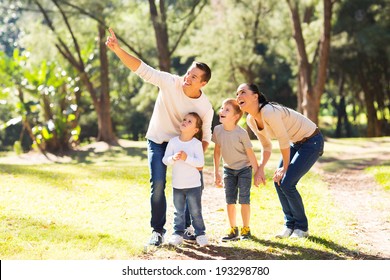 happy young family bird watching in forest