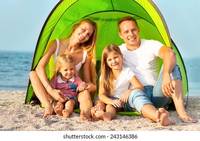 Happy Young Family Camping On The Beach. Summertime