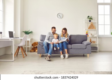 Happy young family with child sitting on comfy soft gray couch in spacious studio apartment or living-room of new house, reading book together, enjoying quiet leisure time on weekend at home - Powered by Shutterstock