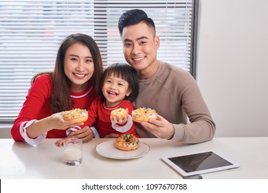 Happy Young Family With Children Enjoying Breakfast In A White Sunny Dining Room With A Big Garden View Window