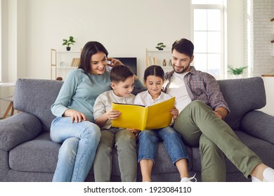 Happy young family with children enjoying free time resting on couch at home. Parents and kids sitting on soft comfy sofa, reading book of fairy tales or looking through holiday photo album together - Powered by Shutterstock